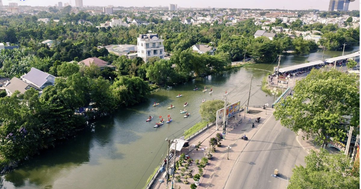 Đoàn thuyền và SUP di chuyển trên rạch Búng nhìn từ trên cao, phường Thuận An