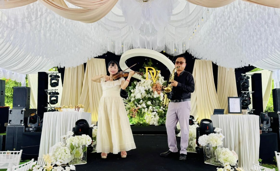 Đội hình hoà tấu saxophone và violin của NTSax Media Entertainment biểu diễn trên sân khấu tiệc cưới
