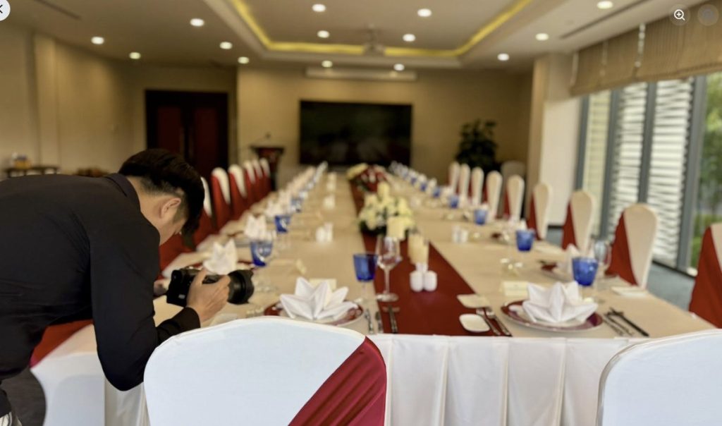 Nhiếp ảnh gia chụp cận cảnh bàn tiệc trước khi khách mời vào phòng